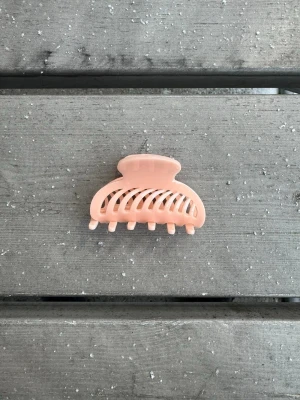 Ljusrosa hårklämma  - Söt ljusrosa hårklämma i klassisk bågform och med silikon på insidan för bättre grepp. Perfekt för att snabbt sätta upp håret med en enkel och stilren look. Söt, stabil och hållbar 