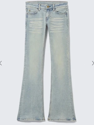 Weekday jeans 26/30  - Säljer ett par ljusblå bootcut jeans med snygga slitningar framtill och klassisk femficksdesign. Jeansen har låg midja och utsvängda ben, perfekta för en trendig och avslappnad look. Tillverkade i denim med en skön tvättad finish.! Bra skick bara lite smutsiga nertill som nog går bort i tvätten 