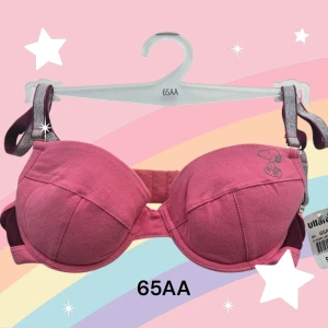 Rosa vadderad Snobben bh storlek 65AA - Söt rosa (rödrosa) bh med ett charmigt Snoopy-motiv. Tillverkad i mjuk bomull med en liten andel elastan för extra komfort. Perfekt för en avslappnad stil med justerbara och avtagbara axelband i glittrigt material. Uttagbara inlägg. Orginal 2000-stil. Oanvänd med prislappen kvar. Kommer från ett restlager. Se också mina andra annonser för möjlighet till att köpa bundle med 20% rabatt och insparad frakt.