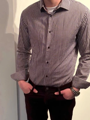 Matinique skjorta i M  - Snygg rutig skjorta i svart och vit med klassisk krage och knäppning framtill. Skjortan har lång ärm och en normal passform, perfekt för en stilren look. Tillverkad i bomull för en bekväm känsla hela dagen.