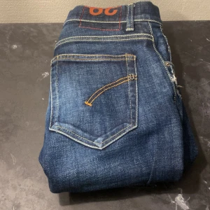 Blå slitna DonDup jeans med slitningar - Säljer ett par blå Dondup Jeans i tajt model med små slitningar säljs för bra pris nu in och köp för endast: 670kr!!! Priset är inte helt satt men hojta till vid intresse.
