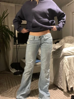 Ljusblå lågmidjade bootcut jeans  - Säljer ett par ljusblå lågmidjade bootcut jeans från Zara Women. Modellen på bilderna är 167cm och är för långa för henne. De är insydda mellan benen. Tvärs över midjan 38cm, innebenslängd 81cm. Se bild 6, där det är vita prickar, misstänker att det kan vara någon sorts av blekning, därav kan jag sälja de för billigare💘