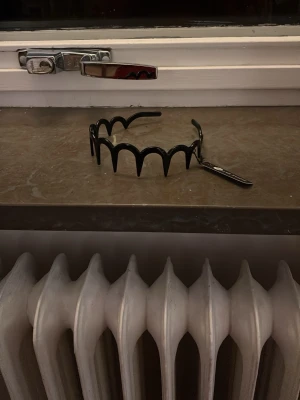 Svart trendig hårband från Montini - Säljer ett svart hårband från Montini med trendig vågig design. Perfekt för att ge frisyren en extra edge. Hårbandet är gjort i blank plast och har en modern look som sticker ut.