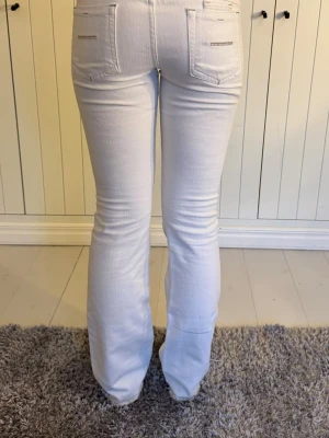Vita bootcut jeans från Yanük - Vita jeans från Yanuk i storlek w27. Modellen är bootcut och låg midja. Använda 2 gånger. Har tagit ner jeansen längst ner så de skulle bli längre, tycker även det blir snyggare!