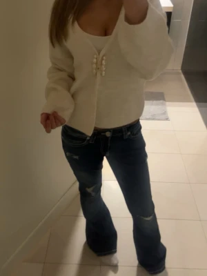 Mörkblå bootcut jeans med slitningar - Mörkblå lågmidjade jeans med slitningar. Dom sitter perfekt och har bara använts en gång💕