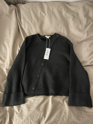 Mörkgrön kofta från Gina Tricot - Säljer en mörkgrön, stickad kofta från Gina Tricot i storlek 158/164. Koftan har rund hals, långa ärmar och knappar framtill. Materialet är mjukt och fluffigt. Aldrig använd 💚