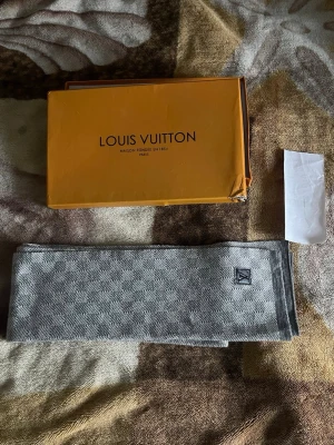 Grå rutig Louis Vuitton halsduk - Louis vuitton scarf  Neo Petit Damier Scarf   Og pris: 6880kr  Säljer för: 1000kr   Köpt av reseller Kvitto tillkommer *dock skadat*   Kan mötas upp i Skåne annars får köpare stå för frakten  