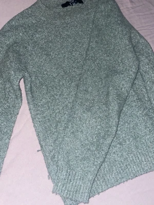 Grå stickad tröja från Vero Moda - Mysig grå stickad tröja från Vero Moda i storlek XS. Tröjan har en klassisk rund hals och långa ärmar med ribbade muddar. Perfekt för kyliga dagar och enkel att matcha med jeans eller kjol. Snygg och enkel design som funkar till många stilar. Tröjan har även blivit tvättad ett par gången så den har bliviy lite mindre, kontakta mig gärna för en bild när den sitter på!