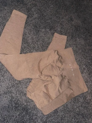 Bruna leggings från NVGTN - Säljer ett par snygga bruna leggings från NVGTN med hög midja och stretchigt material. Knappt använda. 