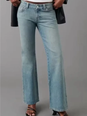 Bootcut ljusblå jeans - Snygga ljusblå bootcut jeans med klassisk femficksdesign och knappgylf. Jeansen har en rak och något utsvängd passform nedtill, vilket ger en cool siluett. Materialet är klassiskt denim i bomull och de har en låg midja. Skriv för bilder den har fickor med knappar 