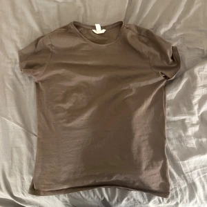 Brun basic t-shirt i bomull - Enkel brun t-shirt i mjuk bomull med rund halsringning och korta ärmar. Från h&m i storlek M.
