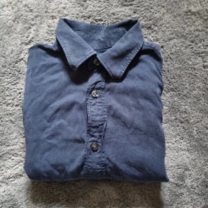 Blå skjorta från Oscar Jacobson - Snygg blå skjorta från Oscar Jacobson🔥 med klassisk krage och knäppning framtill. Skjortan är tillverkad i mjuk bomull🙌 och har en stilren, enkel design som passar perfekt till jeans. Ny pris på dem är 1099kr säls för 429kr🙌🔥 Skick 9/10🔥
