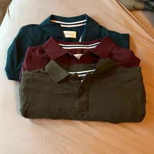 Tre pikétröjor  - Säljer tre stilrena pikétröjor från pier One i färgerna turkos, vinröd och mörkgrön. Klassisk krage, knäppning med två knappar och diskret randig detalj på insidan av kragen. Perfekt för dig som vill ha en clean och tidlös look.