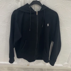 Svart hoodie från Polo Ralph Lauren - Svart hoodie från polo ralph lauren, funkar för båda könerna, köpte början av februari 2025 för 2000kr, har knappast haft på mig den och finns inga fel eller fläckar på koftan, priset går o diskuteras 