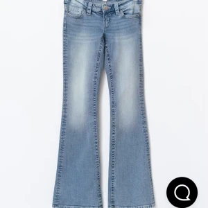 Bootcut ljusblå jeans med slitningar - Snygga bootcut jeans i ljusblå tvätt med slitningar och klassisk femficksdesign. De har rosa ränder på fickorna. De är i nytt skick och inte använda