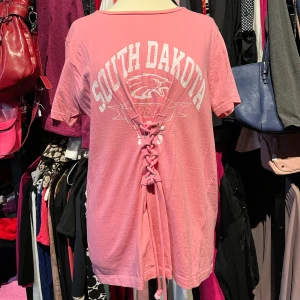 Rosa t-shirt med snörning - Cool rosa t-shirt med tryck 'South Dakota' och en unik snörningsdetalj framtill. T-shirten har rund hals och korta ärmar. Stor M/Normal L