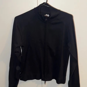 Svart ziptröja från 157, stl M - Svart långärmad ziptröja från 157 i storlek medium. Tröjan har dubbel dragkedja framtill och en enkel, stilren design med hög krage. Perfekt för lager-på-lager och funkar lika bra till träning som chill. Aldrig använd 