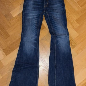 Blå bootcut jeans från Flame - Snygga mörkblå jeans från Weekday med bootcut-passform och slitningar framtill. 