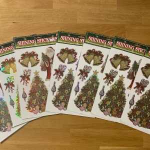 7 Shining Stickers Julmotiv - Flera ark med återanvändbara julklistermärken med motiv som julgran, tomte, klockor och juldekorationer. Perfekt för att dekorera fönster, paket eller pyssel. Klistermärkena är i nyskick och lätta att ta bort utan att lämna märken. 20kr styck 