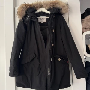 Woolrich jacka dam XS - Svart Woolrich jacka i storlek XS. Normal i storleken. I mycket fint skick utan defekter eller andra anmärkningar, precis som ny. Använd fåtal gånger under 1 vinter och väl omhändertagen. Finns att hämtas i Kungsbacka, annars står köparen för frakten. 