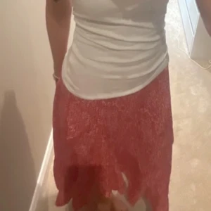 Röd blommig kjol med volang  - Supersöt röd kjol från SHEIN med vitt blommönster och volangig nederkant. Kjolen har en asymmetrisk form som ger en extra snygg touch och är i en lätt och luftig polyester. Perfekt för dig som gillar färg och mönster! Kjolen är i stoleken XS. Skriv såklart till mig ifall du har några frågor eller funderingar!!💕