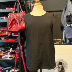 Svart ärmlös topp med leopardmönster - Svart ärmlös topp från Crocker i storlek S. Framsidan är enkel och stilren medan baksidan har ett transparent tyg med diskret leopardmönster. Toppen har en rak passform.