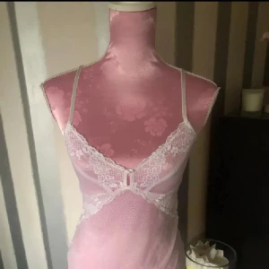 spetsig linnetopp med smala band - Säljer en linnetopp med tunna axelband och vacker vit spetsdetalj framtill. Toppen är figurnära och har en feminin v-ringning med spets som ger en romantisk vibe. Perfekt för dig som gillar söta och trendiga toppar med lite extra detaljer.