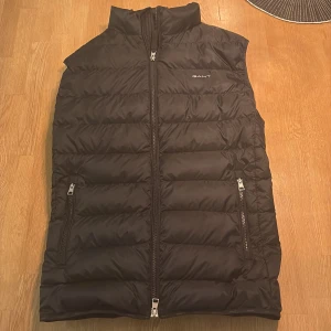 Svart dunväst från GANT, storlek M - Svart väst från GANT i storlek M, skick 10/10, knappt använd, nypris 2500kr