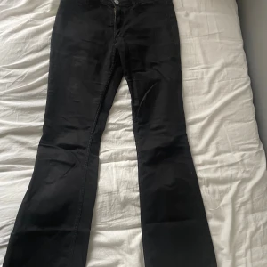 Svarta low waist flare jeans från H& - Svarta jeans från H&M med flare-ben och låg midja. Justerbar midja för extra komfort. Klassisk femficksmodell med knapp och dragkedja framtill. Skriv privat för egna bilder eller mått💕💕