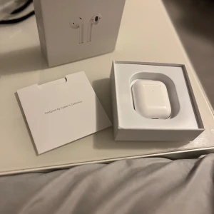 Apple AirPods gen 2  - Säljer ett par Apple Airpods gen 2 eftersom jag jag fick dem som födelsedagspresent men behöver ej dem. Airpodsen kommer komplett med originalförpackning, laddningskabel och dokumentation.  Perfekt för trådlös musik och samtal.
