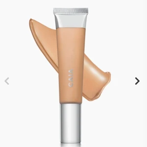 Foundation i tub från CAIA - Bare glow i en smidig tub med silverfärgat lock från CAIA. Färgen är en varm beige nyans som ger en naturlig finish. Perfekt för att jämna ut hudtonen och skapa en fräsch bas. Tuben är lätt att ta med i väskan.  Aldrig använd endast testad men tyvärr fel färg! Så i nytt skick. Färg 20 