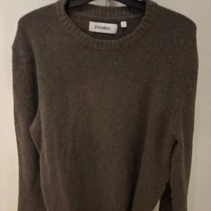 Brun stickad tröja från Strömberg - Mysig brun stickad tröja från Strömberg i storlek S. Tröjan har rund halsringning, ribbade muddar och en liten detalj med italiensk flagga . Perfekt för kyliga dagar och enkel att matcha med jeans