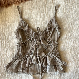 Topp med volanger - Säljer denna supersöta volang toppen från newyorker. Perfekt på sommarkvällar och styla med jeans eller kjol. Har ej använt.