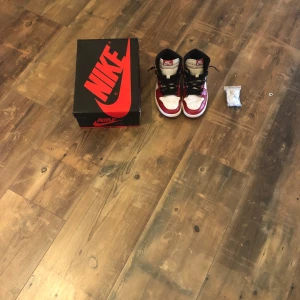 Nike Air Jordan 1 Chicago Highs - Säljer ett par ikoniska Nike Air Jordan 1 Chicago Highs med klassisk röd, vit och svart färg. Skorna har snörning, perforerad tå och rund tå. Tillverkade i skinn med svart swoosh på sidan och högt skaft. Box och extra skosnören medföljer.