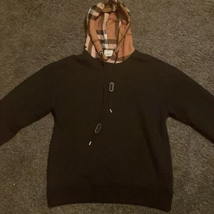 Svart Burberry hoodie - Svart hoodie från Burberry i storlek S. Endast använd 1 gång. Lite liten i luvan annars bra passform