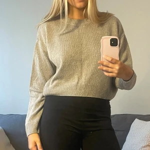 Grå stickad tröja - En stilren grå stickad tröja med rund halsringning och långa ärmar. Perfekt att matcha med jeans eller kjol för en mer uppklädd stil. 😊