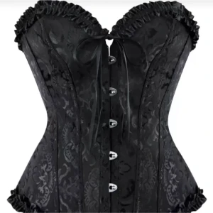 Svart korsett med rosett och mönster - Säljer en svart korsett med snyggt blommigt mönster och dekorativa knappar framtill. Toppen har en söt rosett vid halsen och volangkant längs överdelen. Perfekt för dig som vill ha en statement piece i garderoben!