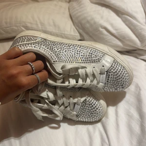 Vita sneakers med glittriga stenar - Säljer ett par vita sneakers från Aldo med glittriga paljettdetaljer över hela skon. Skit snygga glittrar så mycket endast använt 5gånher så dom är försmå🩷🩷 priset kan diskuteras vid snabb affär 