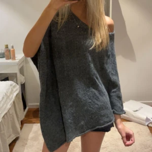 Grå poncho tröja - Säljer en grå stickad  ”poncho” tröja, vet inte riktigt hur man bär den men finns nog flera sätt, finns ingen lapp men tror den är från hm. Skriv för fler bilder.💕