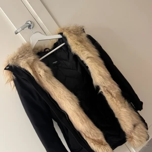 Rockandblue jacka med äkta päls som är avtagbar - Svart jacka från rockandblue med äkta päls som är avtagbar. Jackan är väldigt unik då den har jättefin och fluffig päls men samtligt så är den avtagbar. Jackan är väldigt fin men samtidigt väldigt varm för kalla vintrar. Den har mycket bra skick då jag endast haft på mig den några gånger. 