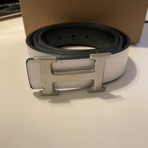 Vitt Bälte - Vitt bälte med silvrigt H