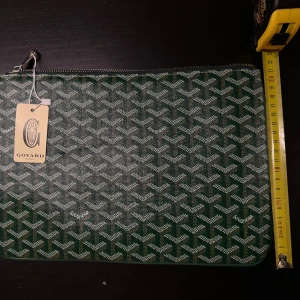 Väska - datorväska  -  Väska - datorfodral – grön Väska i klassiskt mönster. Passar perfekt som datorfodral eller dokumentväska. Mått: ca 30 x 21 cm. Fint skick, aldrig använd. DM för fler bilder eller funderingar.