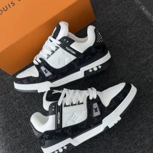 Louis Vuitton svartvita sneakers - Säljer ett par Louis Vuitton sneakers i svart och vitt med klassiskt monogrammönster. Skorna har snörning, platt sula och tydliga LV-detaljer på tungan och sidorna. Tillverkade i skinn och textil med exklusiv känsla och cool kontrast mellan färgerna.