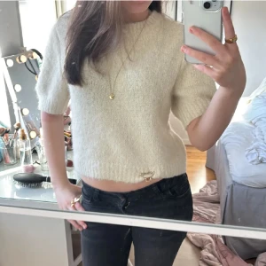 Stickad beige kortärmad tröja - Super snygg stickad tröja som är beige med korta ärmar från Vero Moda. Den är i storlek m men passar mig som har storlek s. Jag säljer den då den aldrig har kommit till användning. Använd gärna köp nu!💕