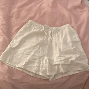 Vita linneshorts med snörning ✨🤍✨ - Säljer ett par vita, luftiga shorts i linne med elastisk midja och snörning framtill. Perfekta för varma dagar och har en avslappnad passform. Stilrena och enkla att matcha med det mesta. 😍😍😍