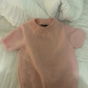 Ljusrosa stickad tröja Gina Tricot - Superfin ljusrosa stickad tröja från Gina Tricot med korta ärmar och rund hals. Använd 1 gång, säljer då jag fick en liknande