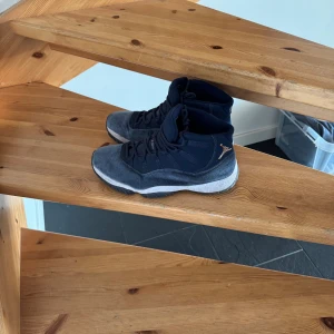 Nike Air Jordan 11 Retro Midnight Navy - Säljer ett par Nike Air Jordan 11 Retro i färgen Midnight Navy. Skorna har en snygg mörkblå ovandel i mocka och textil, vit mellansula och guldiga Jumpman-detaljer på hälen. Klassisk high-top siluett med snörning och rund tå. Perfekta för dig som vill sticka ut med stil.