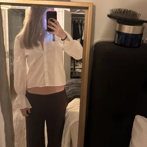 Vit skjorta med knyt från Glamorous - Säljer en vit skjorta från Glamorous i storlek S. Skjortan har långa ärmar med volang vid ärmslut och snygga knytband i ryggen som ger en unik look. Klassisk krage och knappar framtill. Perfekt för dig som vill sticka ut lite extra. 