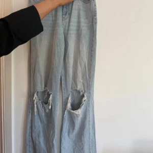 Jeans ”tall” - Säljer ett par ljusblå jeans med slitningar på knäna. Byxorna är i ”tall” modell så passar långa tjejer.