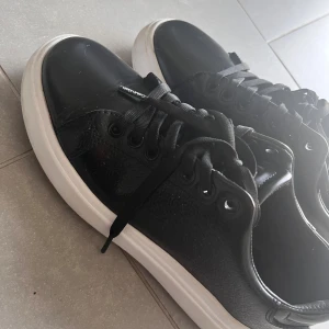 Svarta sneakers från Calvin Klein - Jättefina svarta sneakers från Calvin Klein, materialet är glansigt, lite använda, nypris ca 800 kr🥰